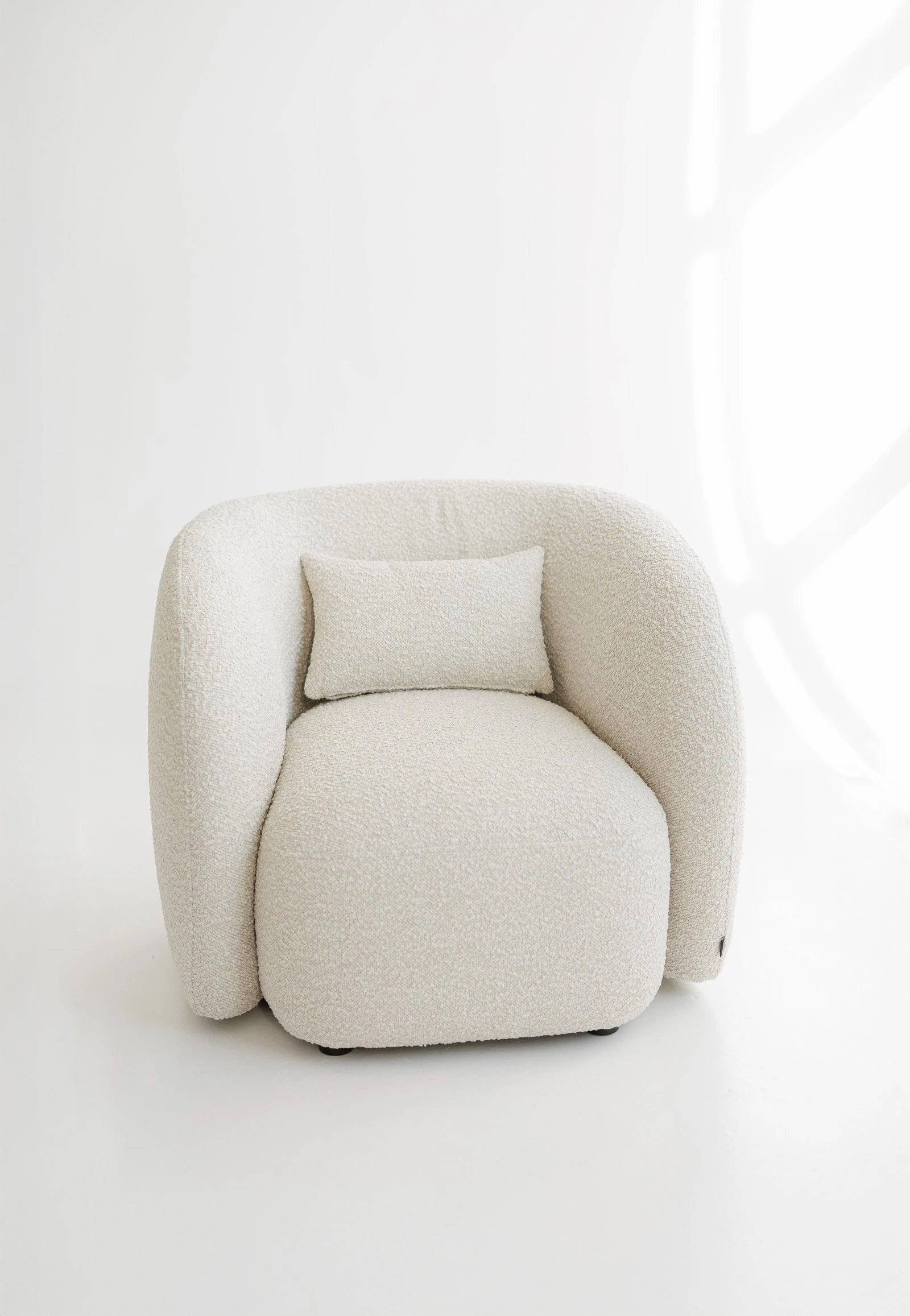 Cream Santa Cruz 801 boucle Nuba armchair photographed in a bright minimal studio