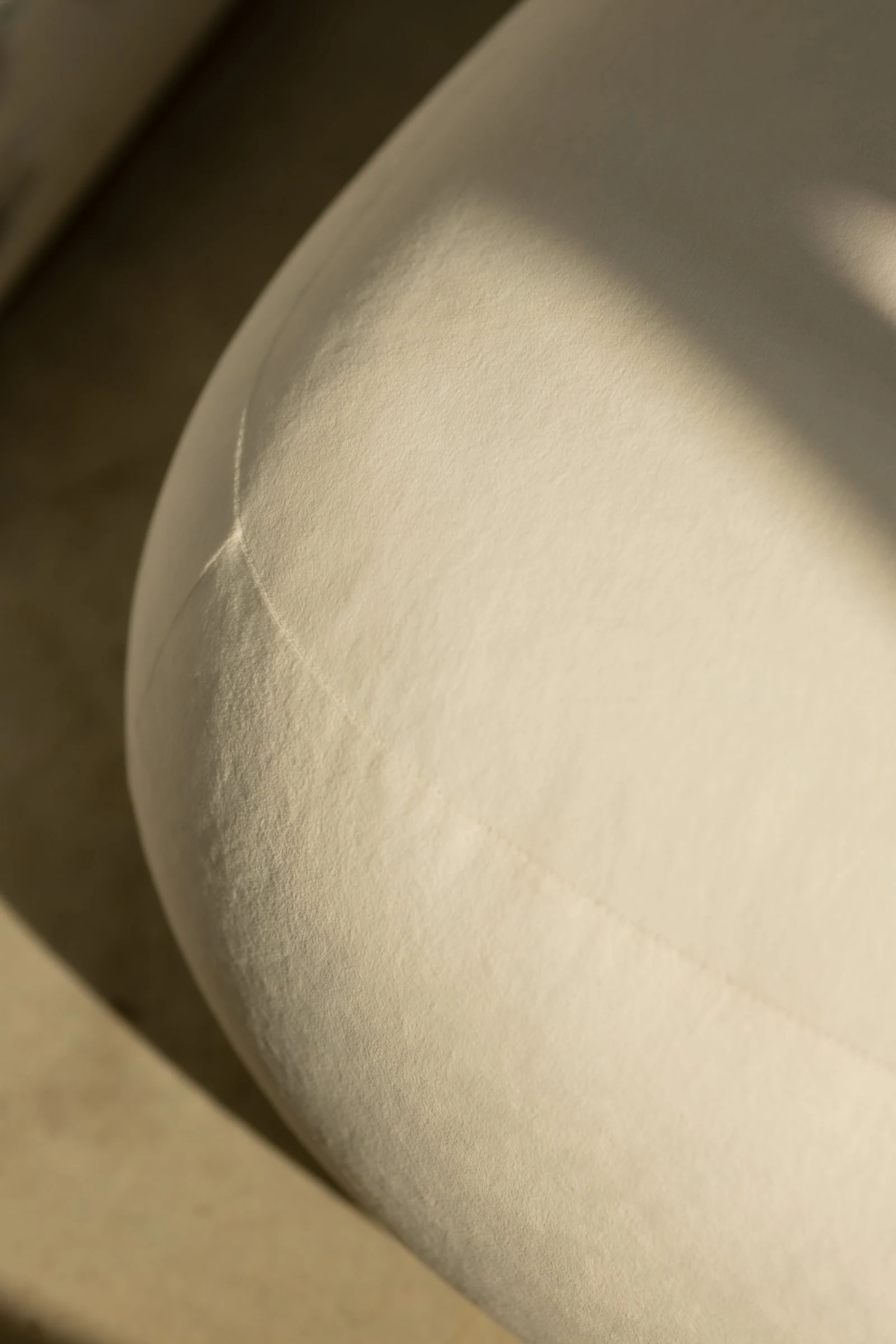 Macro of Amber 900 velvet on a Chios pouf with light raking across the nap