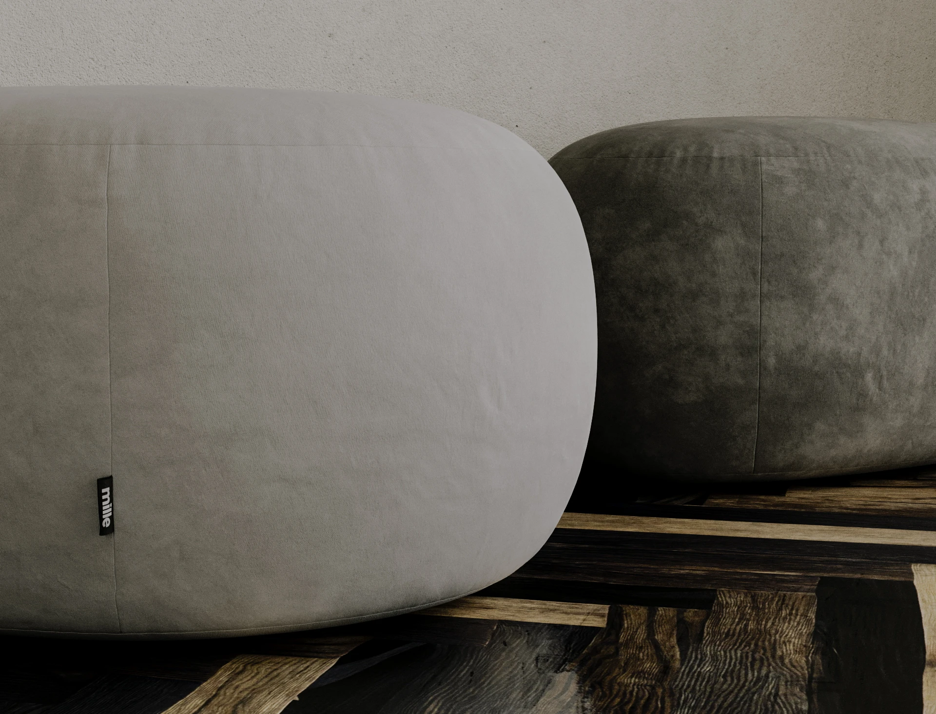 Two grey velvet Chios poufs together on a dark parquet floor