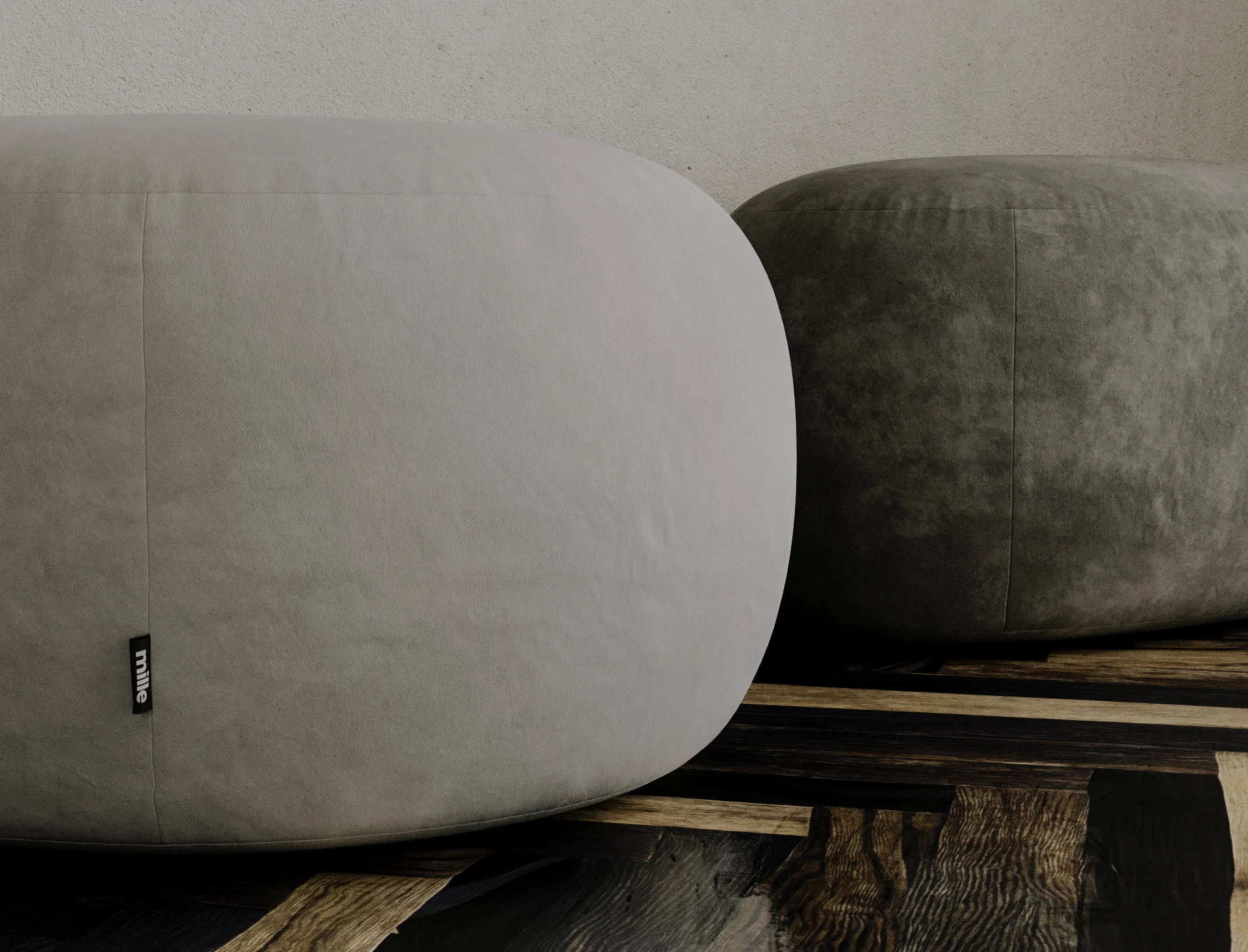 Two grey velvet Chios poufs together on a dark parquet floor