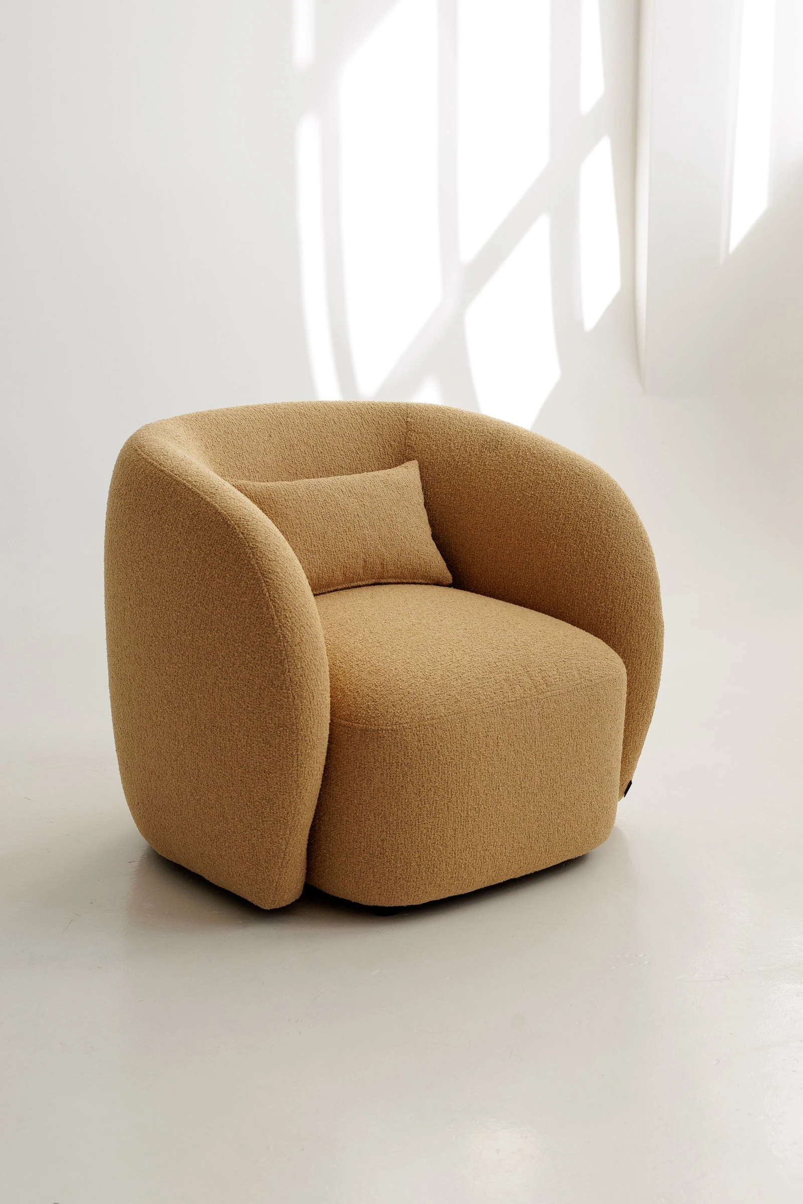 Mustard Everest 103 boucle Nuba armchair photographed in a bright studio