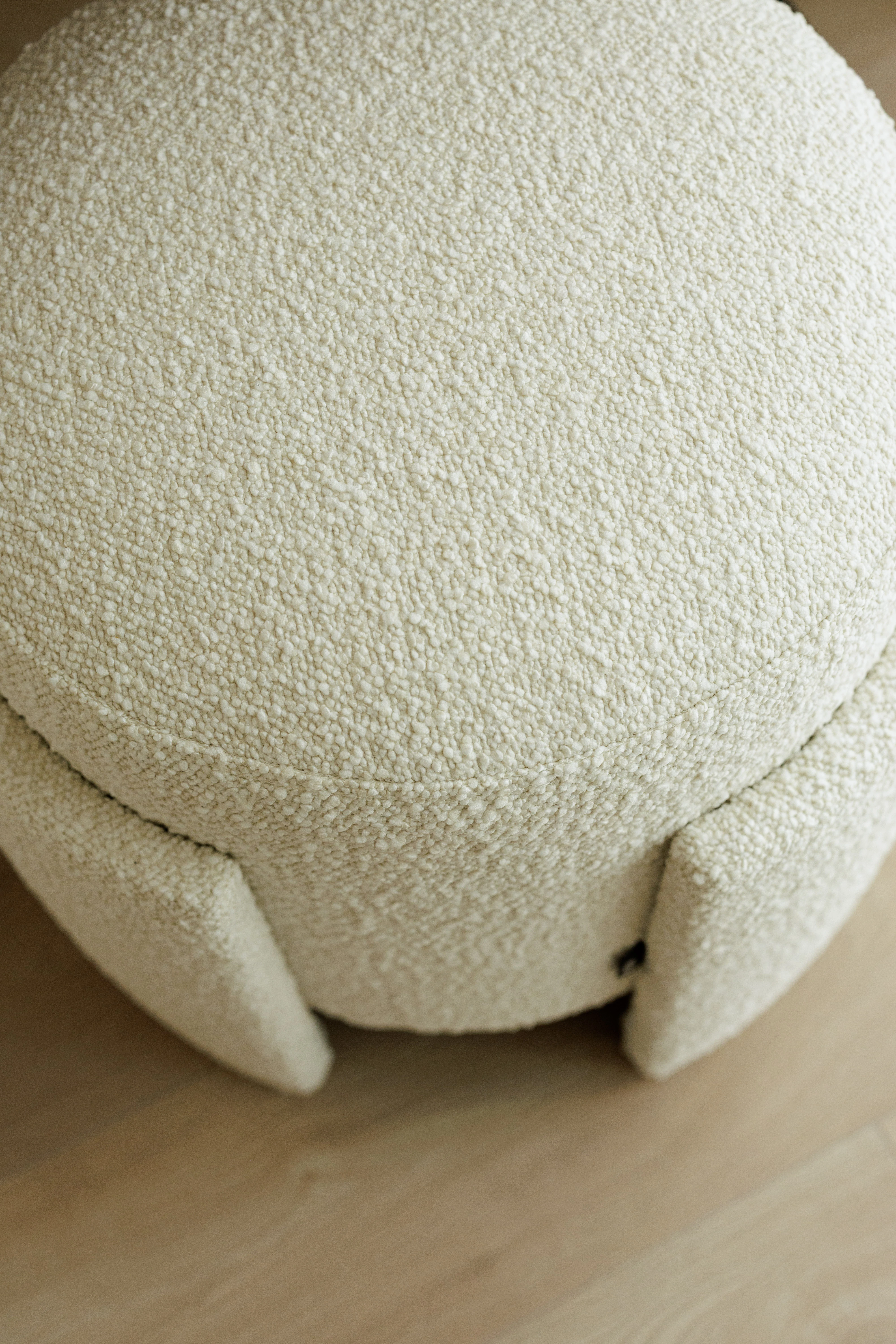 Top-down view of the Eden pouf showing the round drum cushion and the three strap feet