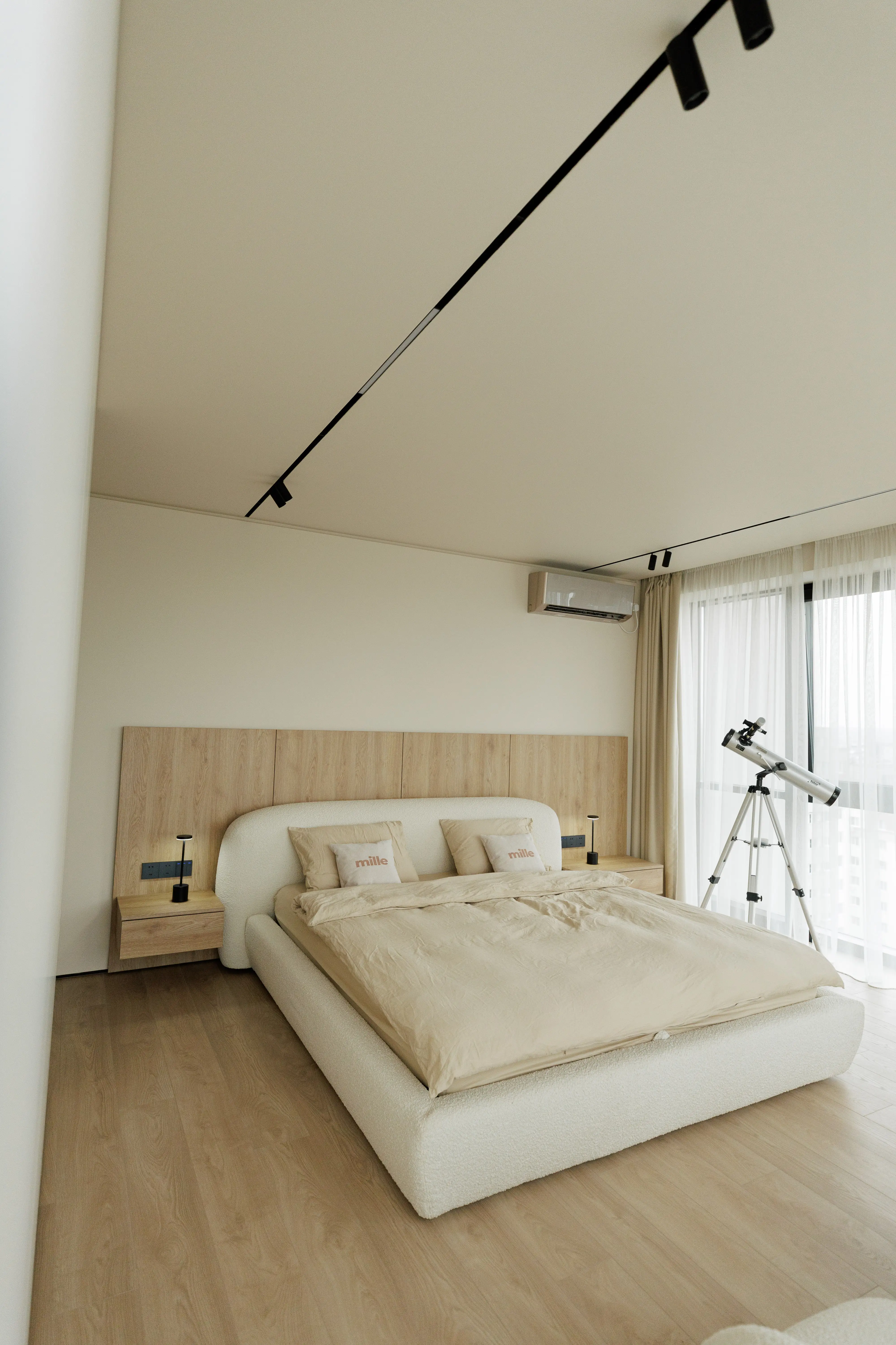 Wide view of the apartment bedroom: Belagio against the wood-paneled accent wall, a small telescope by a floor-to-ceiling window