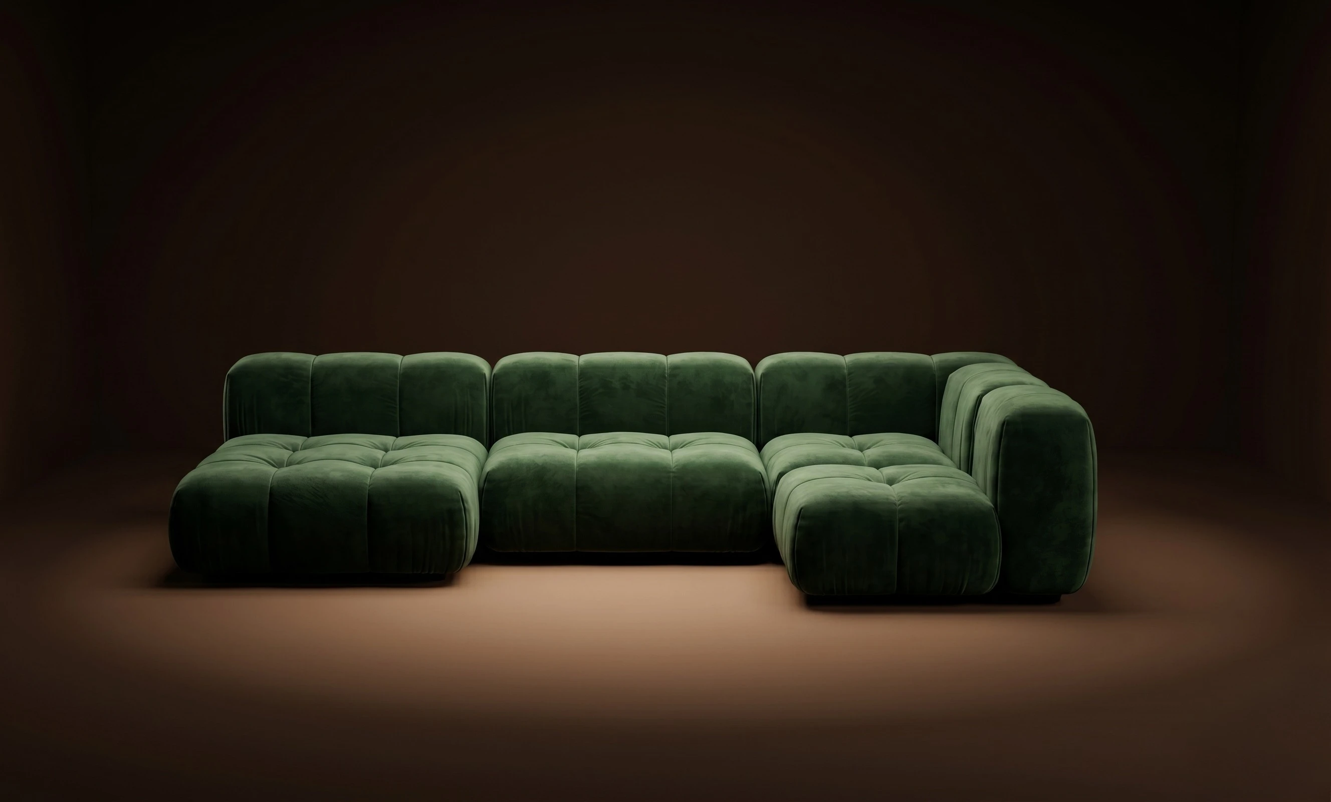A green Mille open L with plush deep cushions, in a dark studio