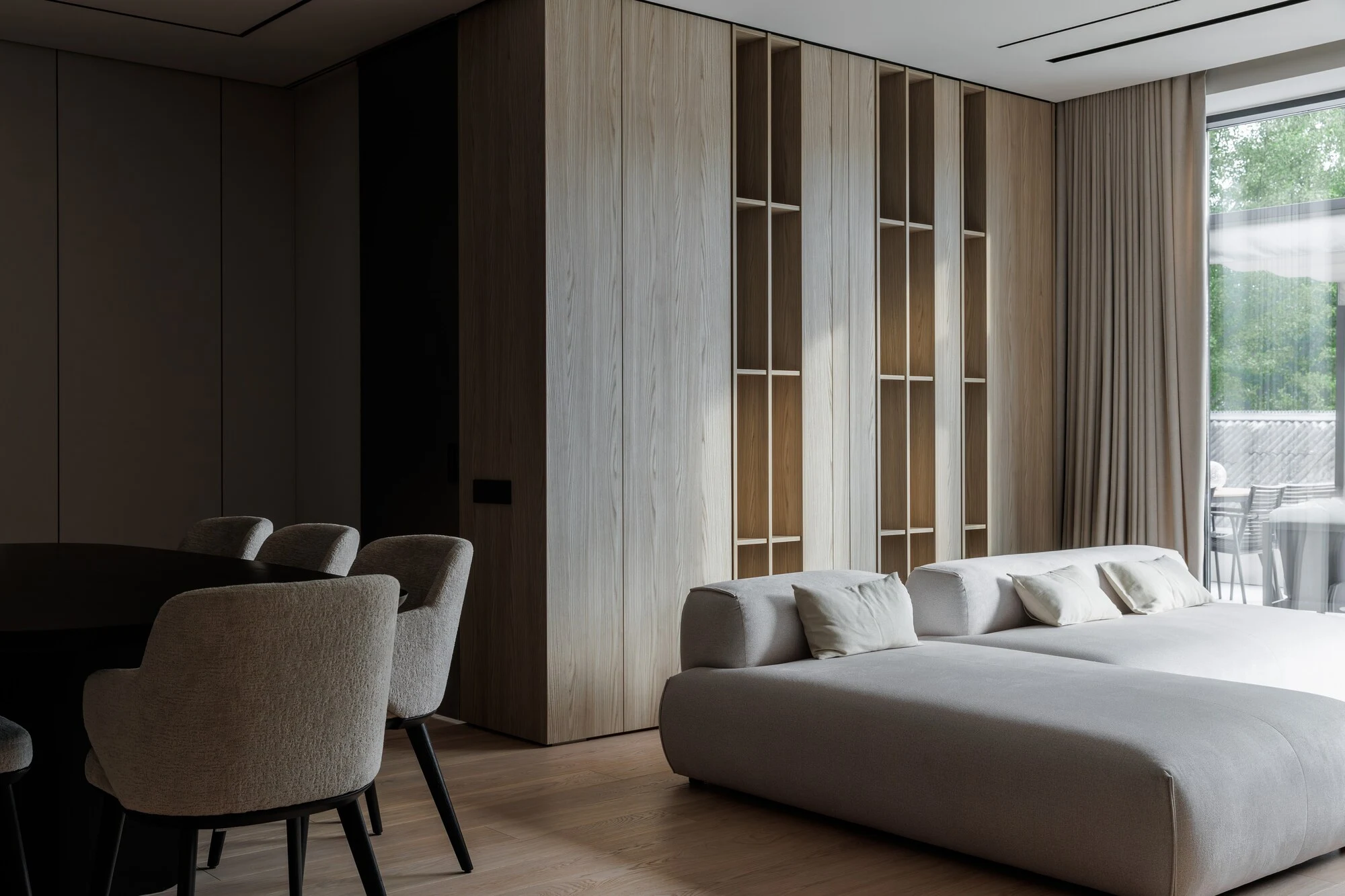 Cream Nissa in the apartment dining area with built-in oak bookshelves and a long table