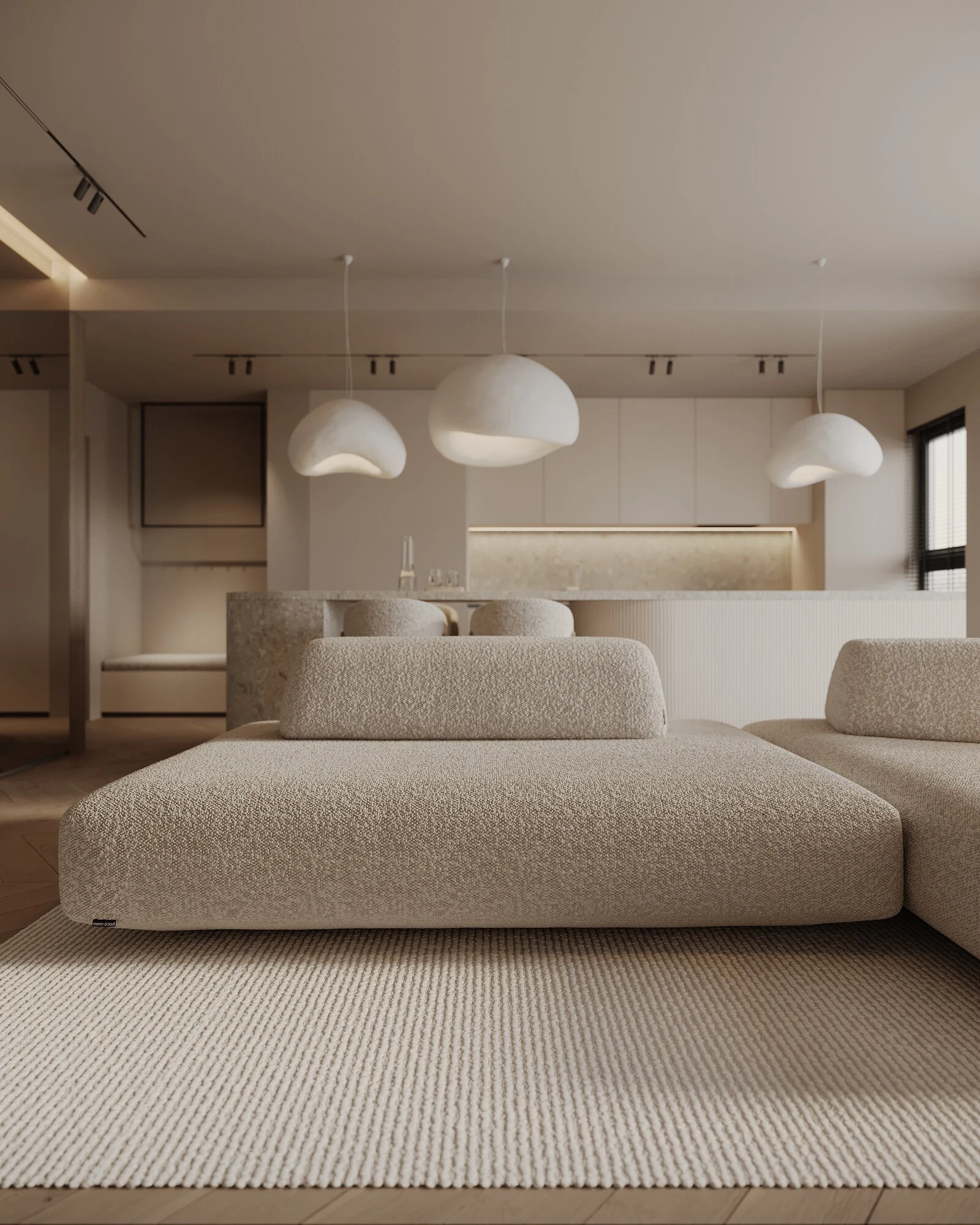 Close view of the cream Deseda beneath sculptural cream pendants in a warm apartment