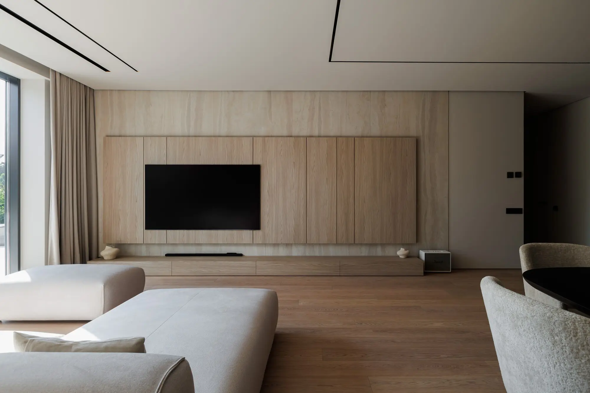 Cream Nissa facing a recessed oak TV wall with a black flat screen