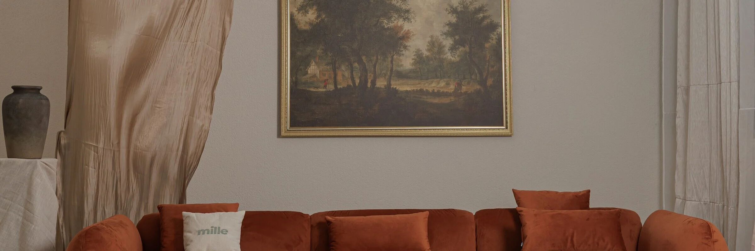 Tesa modular sofa in a softly lit interior, with a sheer curtain and a framed landscape painting on the wall