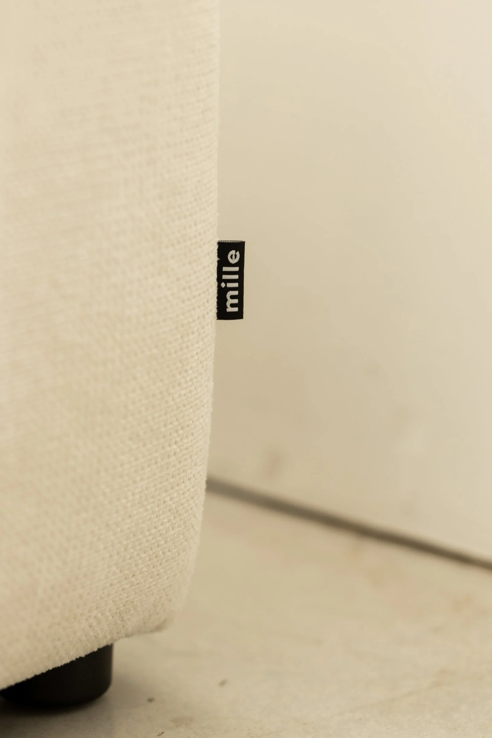 Close detail of the small Mille label sewn into the cream weave at the base of the Marmaris
