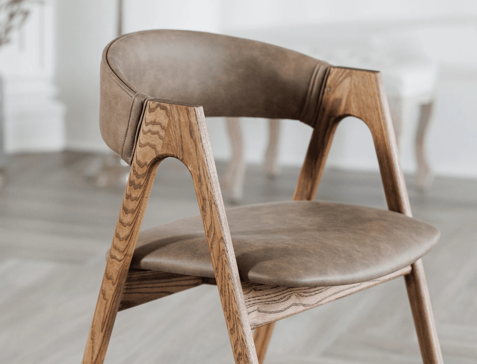 Three-quarter view of the Lain chair on natural-ash frame, showing the sawhorse A-shape legs and the small curved upholstered back