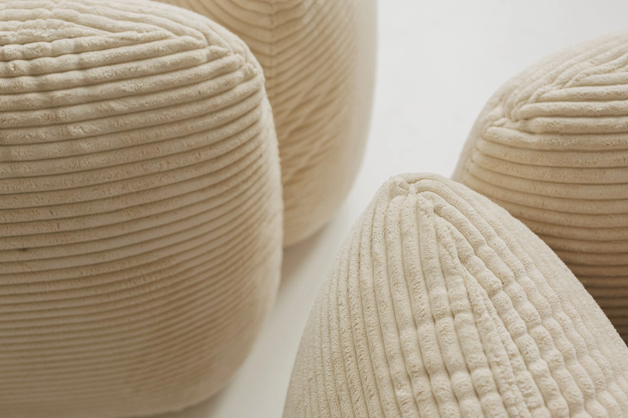 Four oat corduroy Tesa modules clustered on a white studio floor